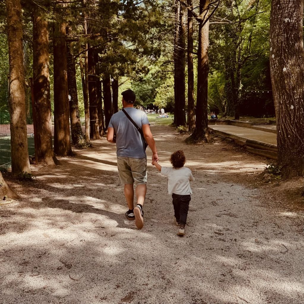 Father and Son Walk on Path Through Trees at Radman Mills